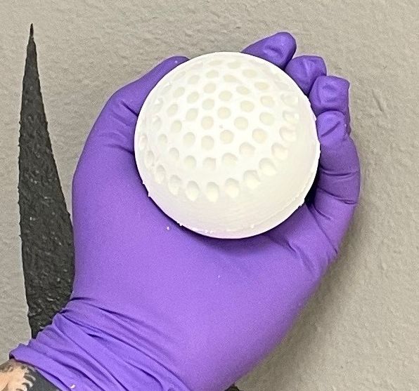 A hand holding the Orchard One \u201cfruit.\u201d