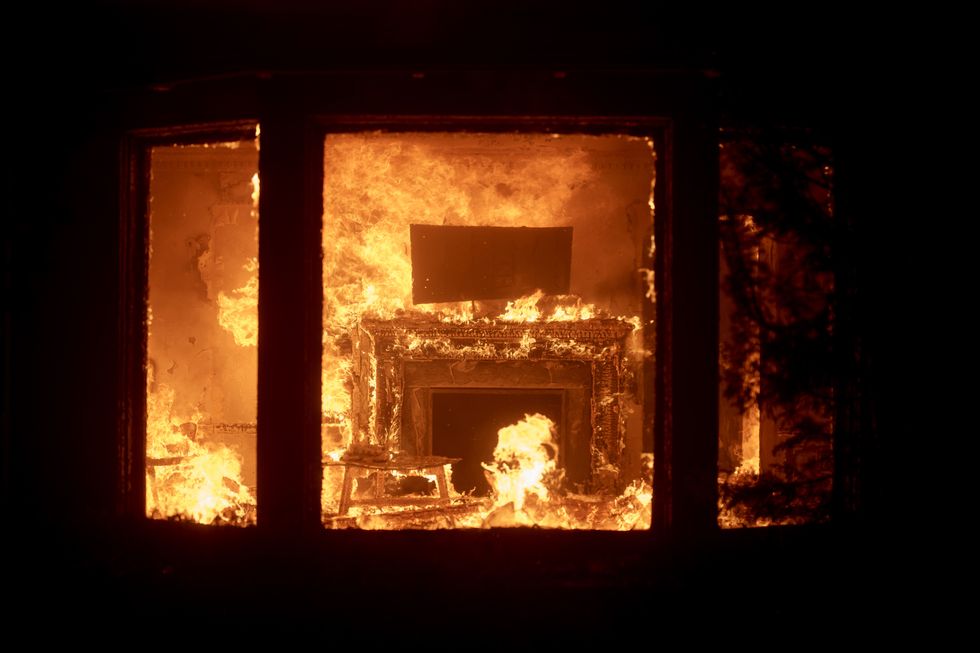 Flames attack the fireplace of a home in Pacific Palisades Tuesday night.