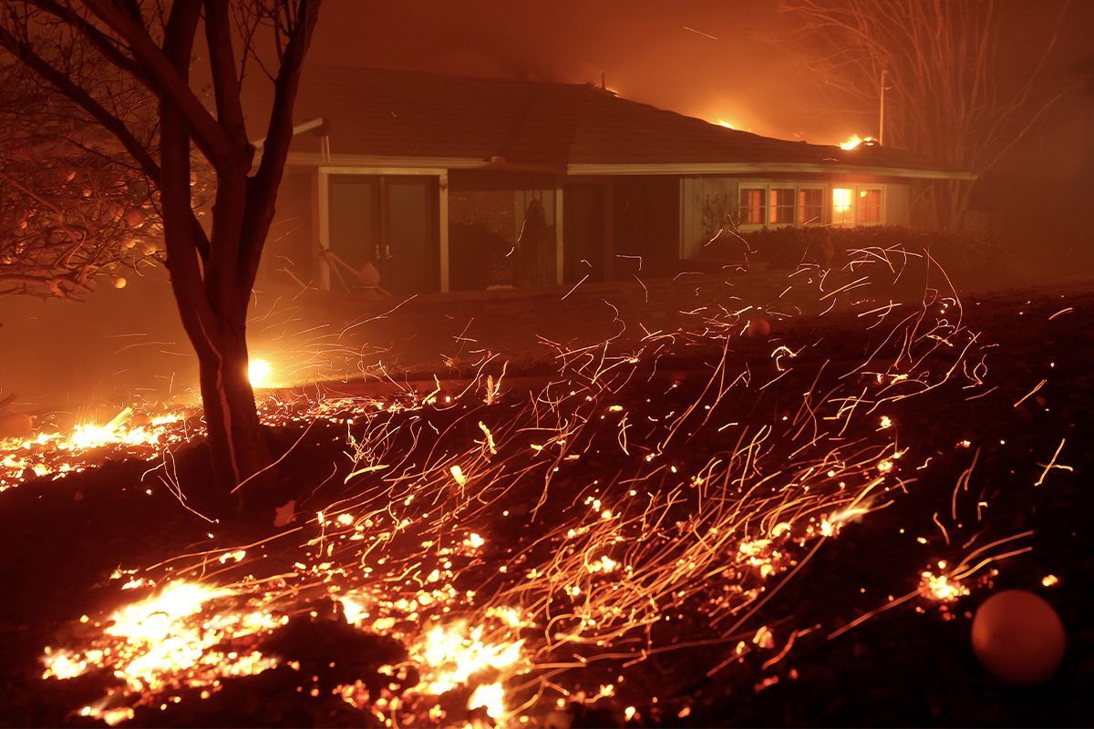 Embers swirl around a house in Los Angeles.