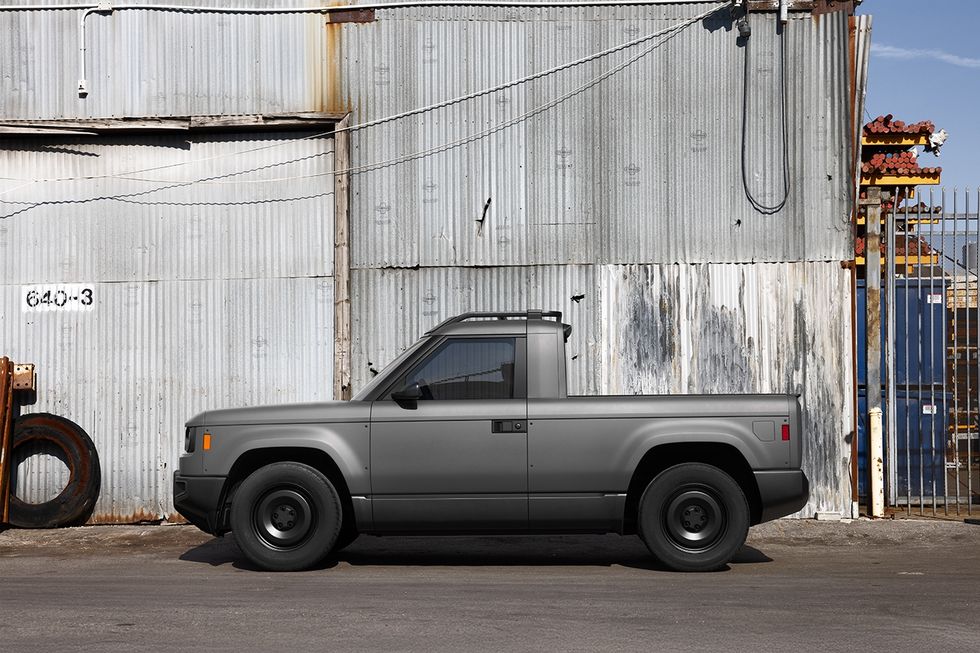 A gray "Blank Slate" truck sits outside a warehouse with sheet metal walls