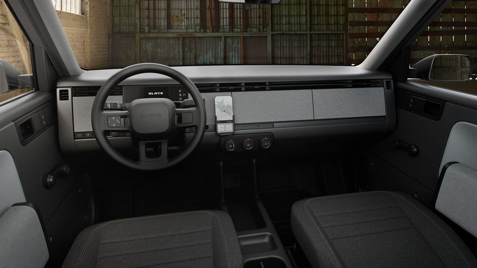 The interior of a Slate truck shows a steering wheel, a place to hold your iPhone, climate control knobs, a hand-cranked window \u2014 and little else.
