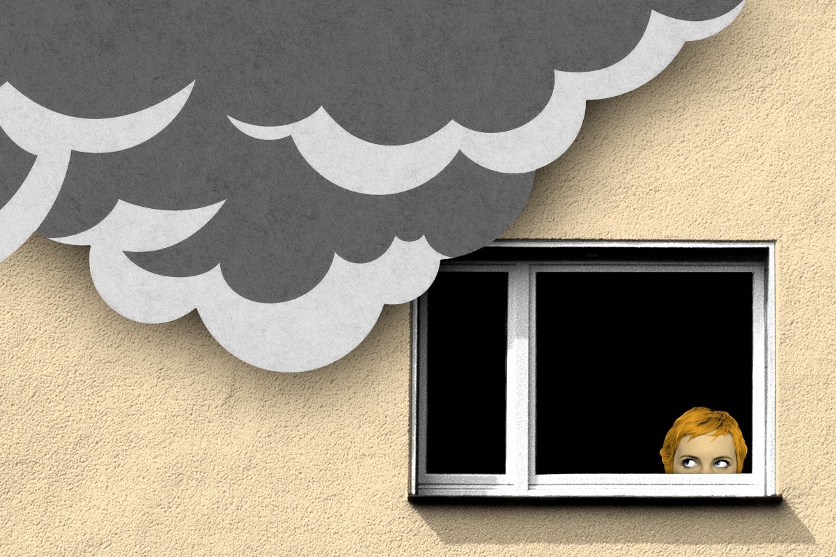 A woman peeking out her window at smoke.