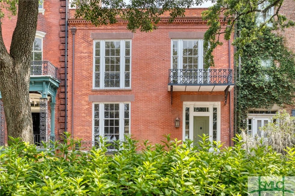 A two-story, red-brick townhome.