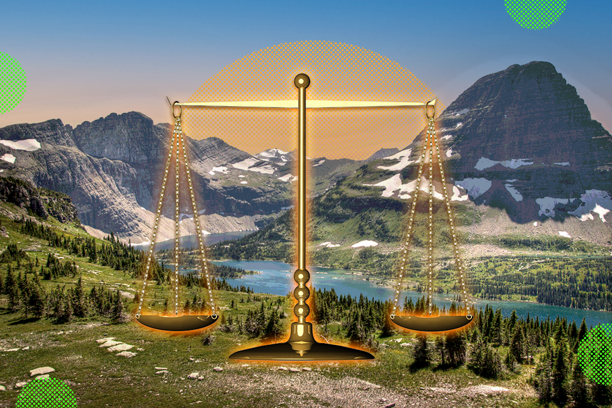Scenic Montana backdrop with scales of justice in the foreground.